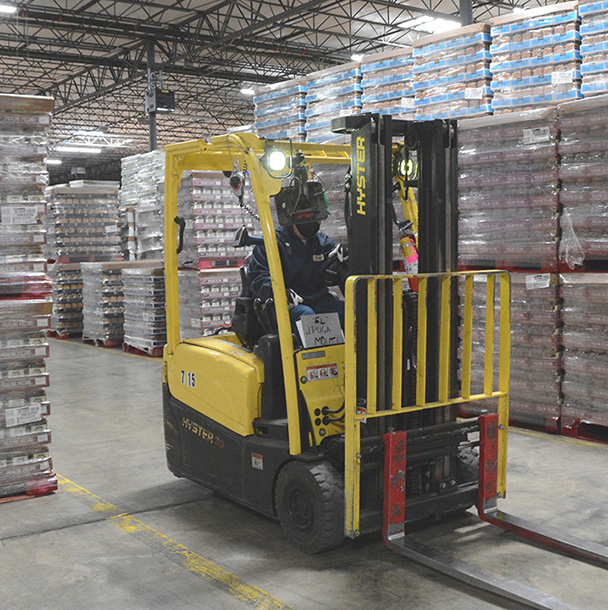 Forklift and forklift driver in plant warehouse